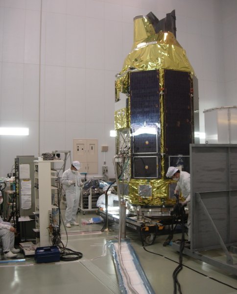 White-clad clean-room engineers adjust cabling and plumbing around the bottom of the 5-meter tall spacecraft. (49K JPEG)