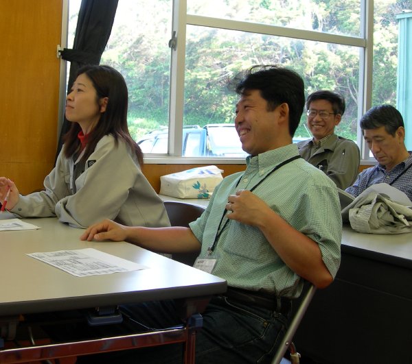 Two engineers, one of each gender, sit smiling at the table. (69K JPEG)