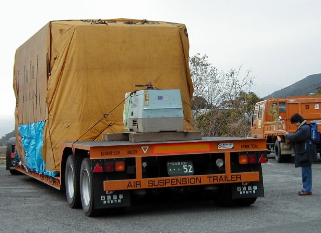 Large blanketed box on a flatbed trailer (69K JPEG)