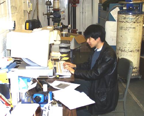 Fujimoto-san looking gleefully at his workstation (36K JPEG)