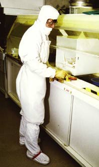Fig. 3: Worker in cleanroom, fully covered
  (boots, suit, gloves, glasses, mask and hood)